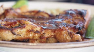 Sulu ızgara tavuk renkli sebze ve sosla kaplıdır..