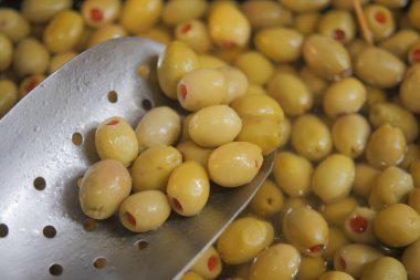 Yeşil zeytinler bir kaseden kepçeleniyor, tombul dokularını sergiliyorlar..