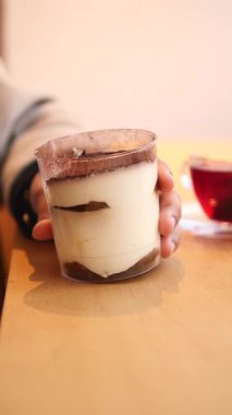 Kafe ortamında bir fincan sıcak çayla lezzetli bir katmanlı tatlının tadını çıkarmak..