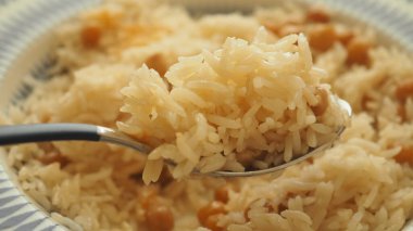 Kaşık üzerindeki bezelyelerle karıştırılmış kabarık pirincin yakın plan görüntüsü, yemeye hazır..
