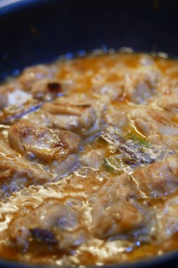 Taze tavuk parçaları fırının üstünde lezzetli bir sosta pişiyor..