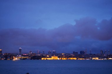 Şehir ışıkları İstanbul 'un alacakaranlık saatlerinde ufuk çizgisini aydınlatıyor.