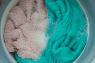 Mavi ve pembe elbiseler sabunlu suda birlikte yıkanır..