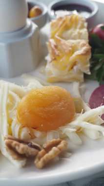 Lezzetli kahvaltıda yumurtalar, taze sebzeler ve lezzetli etler var..