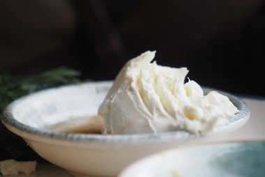 Krem şantili bir kase lezzetli bir tatlıdan sonra davetkar bir şekilde oturur..