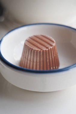 Tatlı bir çikolata ikramı, dokusunu vurgulayan küçük bir kasede sunulur..