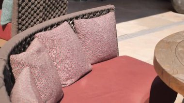 Rahatlatıcı bir yer, dışarıda desenli yastıklar ve kırsal masa var..