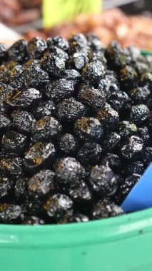 Taze toplanmış siyah zeytinler bir pazarda satılığa çıkarılır..