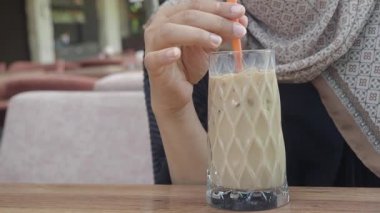 Güneşin altında otururken ferahlatıcı bir buzlu kahveyle rahatlıyorum..