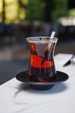 Kafe masasında siyah bir fincan Türk çayı..