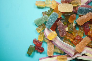 Mavi arka planda çeşitli şeker ve meyve şeritleri var..