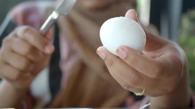 Bir insan nazikçe kaynamış yumurtayı kahvaltıda yemeye hazır tutar..