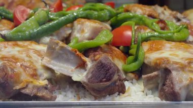 Eritilmiş peynirli et, yeşil biber ve pilav..