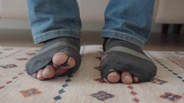 Biri içeride dinlenirken, delikli çoraplar kullanım belirtileri gösterir..