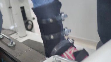 Bir hasta yürüme yeteneğini geliştirmek için rehabilitasyon cihazı kullanır..