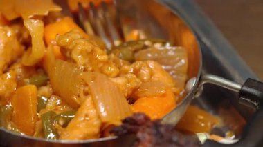 Metal bir kasede lezzetli bir tavuk ve sebze yemeğinin yakın çekimi..