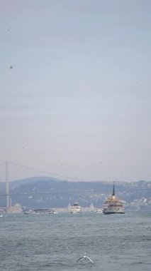 Açık bir günde şehrin silueti yakınındaki sakin sularda birkaç tekne geziniyor..