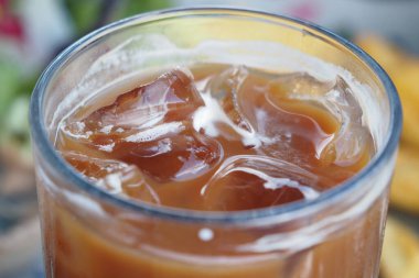 Buzlu kahveyi buz küpleriyle tazelemek yaz için mükemmel güneş ışığında oturur..