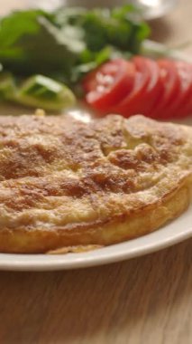 Taze salata ve domates dilimleriyle birlikte ev yapımı omletin tadını çıkarın..