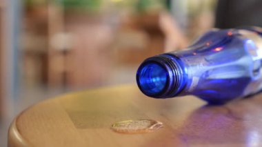 Su şişesinden dökülen su masanın üzerinde duruyor. .