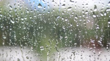 Yumuşak yağmur damlaları pencere camında sakinleştirici bir atmosfer yaratır.