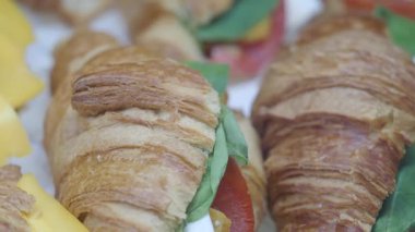 Domates, peynir ve yeşilliklerle dolu lezzetli kruvasan sandviçleri..
