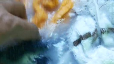 Bir kovada bezleri yıkıyorum. Yakın plan. ,