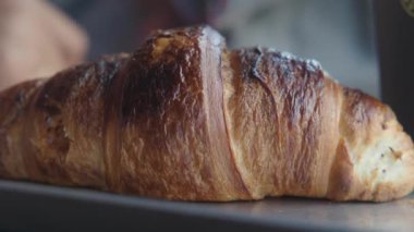 Taze pişmiş kruvasanın sıcak, pul pul dokusunun tadını çıkar..