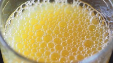 Bu parlak kabarcıklı ve renkli köpüklü bir içeceğin yakın görüntüsünü yakalar.