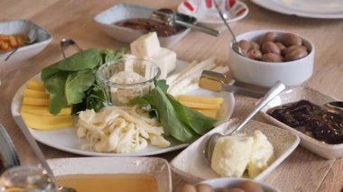 Tahta bir masaya yayılmış zengin ve çeşitli bir kahvaltı..