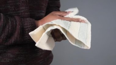 Tarafsız bir mekanda havluyla el temizliği yapıyor..