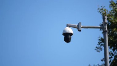 Bir güvenlik kamerası açık bir gökyüzünde çevreyi gözlüyor..