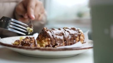 Kafede çikolatayla tatlandırılmış lezzetli bir tatlının tadını çıkaran biri..