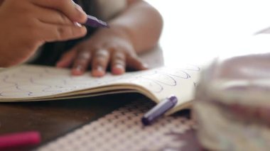 Defterde mor işaretli çocuk çizimi.