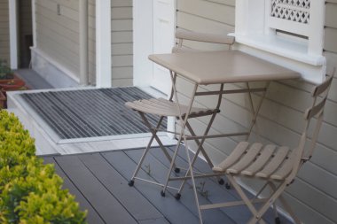 Küçük bir masa ve sandalyeler evin dışında oturup rahatlamaya davetiye çıkarır..