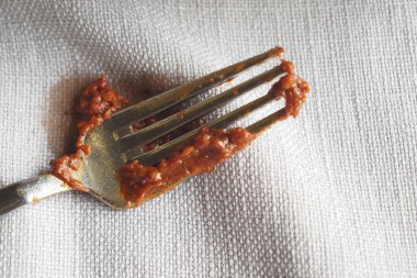 Kahverengi soslu çatal kumaş peçeteye dökülmüş..