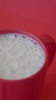 Kırmızı arkaplanda muzlu milkshake. ,