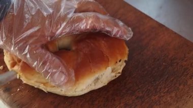 Bir aşçı taze malzemeler ve özenle lezzetli bir sandviç yapar..