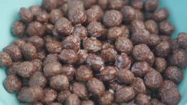 Çikolatalı mısır gevreğinin yakın plan görüntüsü. Süte batırılmış, kasede servis edilmiş..