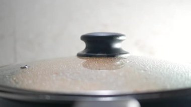 Yemek ocakta pişerken üstü örtülü bir tencereden buhar yükselir ve sıcaklık yaratır..