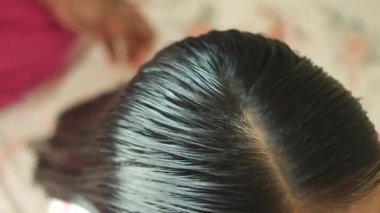 Koyu renk saçların ayrılıp biçimlendirildiği yakın plan..