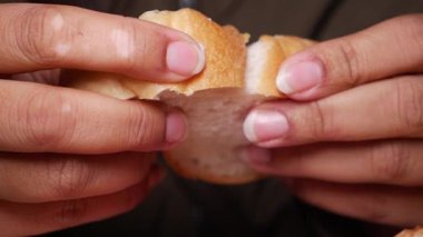 Eller lezzetli ekmeği kavrıyor, yayılarak tadını çıkarmaya hazır..