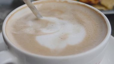 Köpüklü ve aromalı zengin kahveyi karıştırma sürecinin tadını çıkarıyorum..