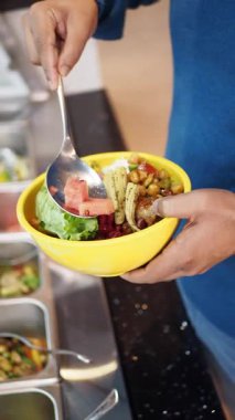 Bir insan taze malzemelerle renkli bir salata yapar..