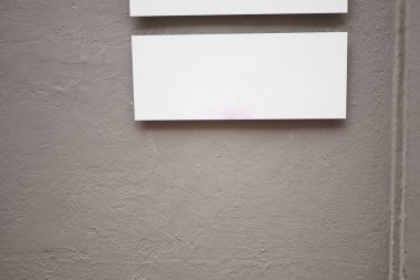 İki boş ekran paneli desenli gri bir duvara monte edilmiştir..