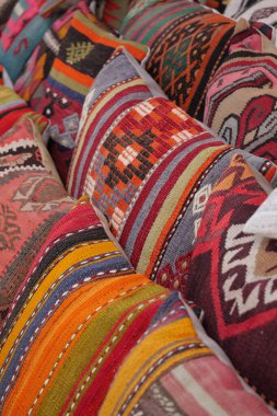 Parlak, desenli yastıklar bir market tezgahında düzgünce düzenlenir..