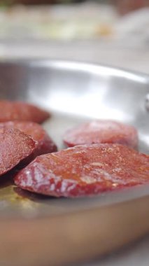 Metal tepside dilimlenmiş sosisler.