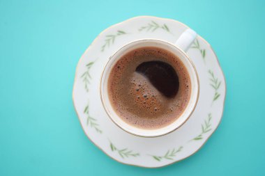 Zengin kahve parlak bir yüzeyde ince bir porselen fincanda oturur..