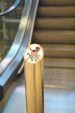 Uyarı levhası, yürüyen merdivenlerin yanına alışveriş arabalarının yaklaşmasına izin verilmediğini gösteriyor..