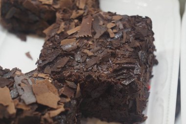 Zengin çikolata, beyaz bir tabakta çikolata parçacıkları ile süslenir..